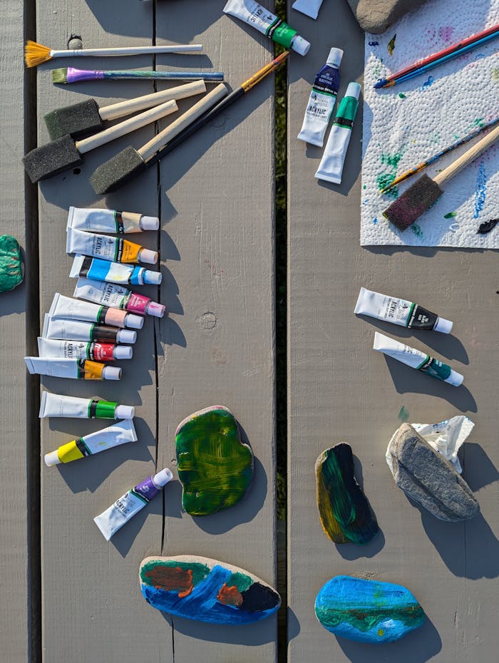 why-choose-us Colorful acrylic paints and brushes arranged on a wooden table outdoors, showcasing a vibrant crafting setup.