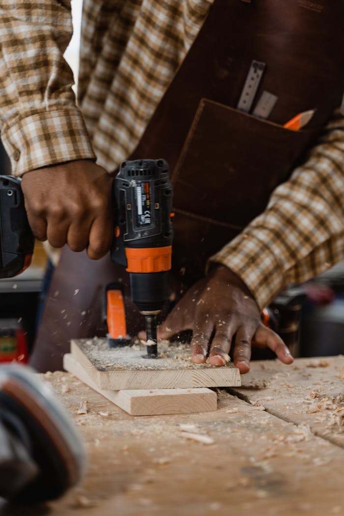 Close-up of a carpenter drilling wood, showcasing craftsmanship and attention to detail.